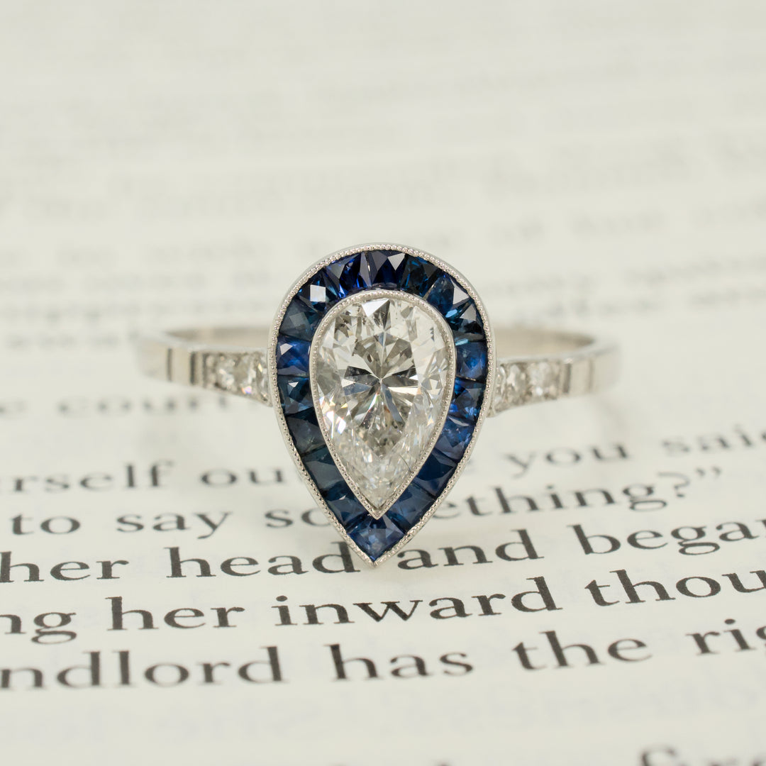 Art Deco Style Platinum Ring with 0.69 Carat Pear Cut Diamond and Sapphire Halo