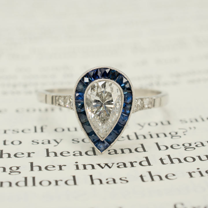 Art Deco Style Platinum Ring with 0.69 Carat Pear Cut Diamond and Sapphire Halo