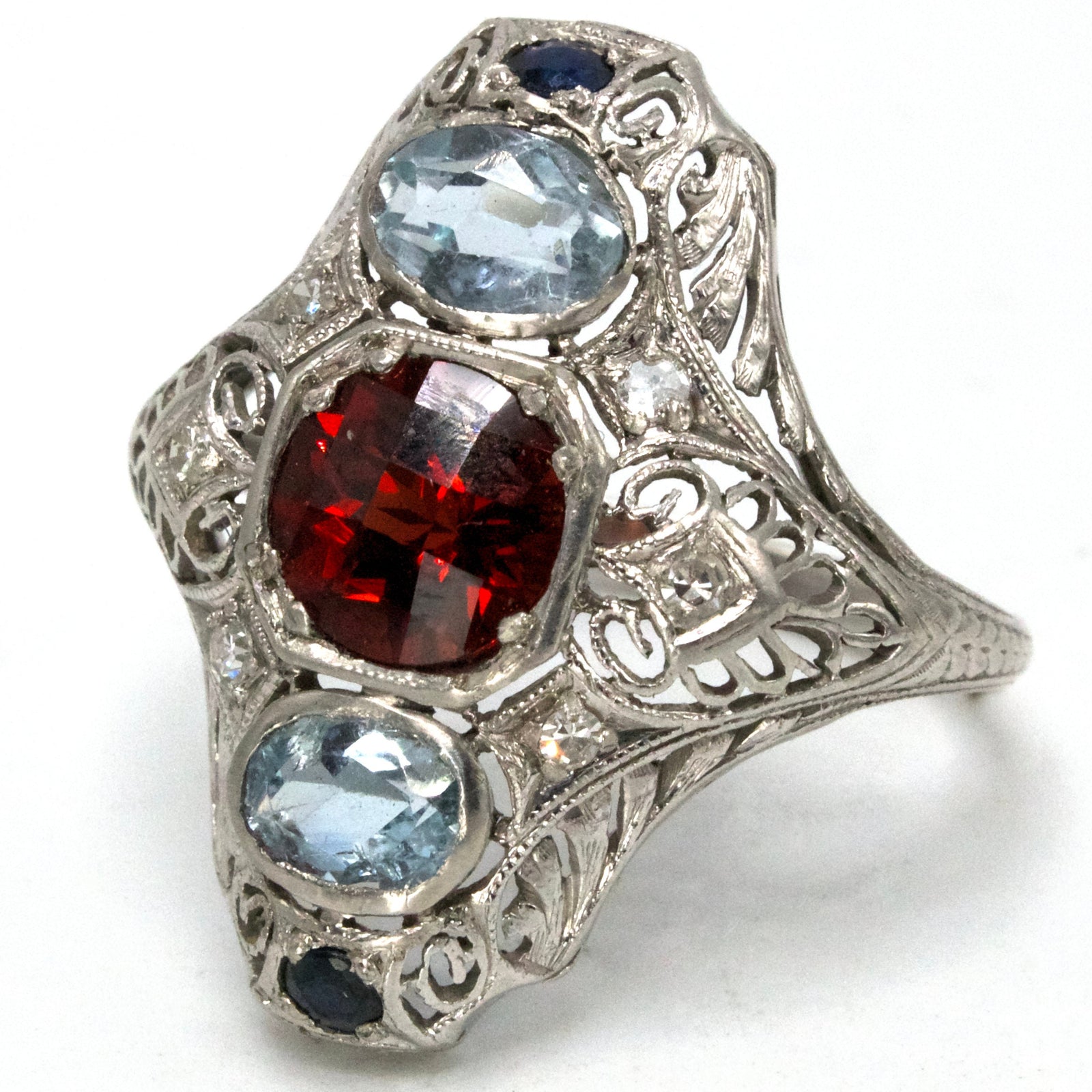 Elongated Edwardian Platinum Ring with Garnet, Aquamarines, Sapphires, and Diamonds