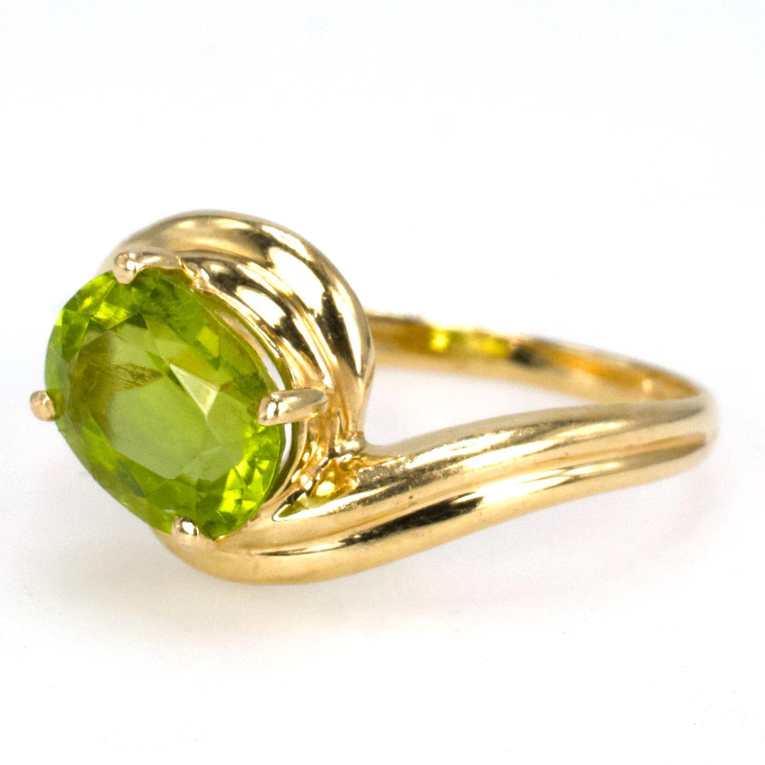 Diagonally Set Oval Peridot Bypass Style Solitaire in Gold