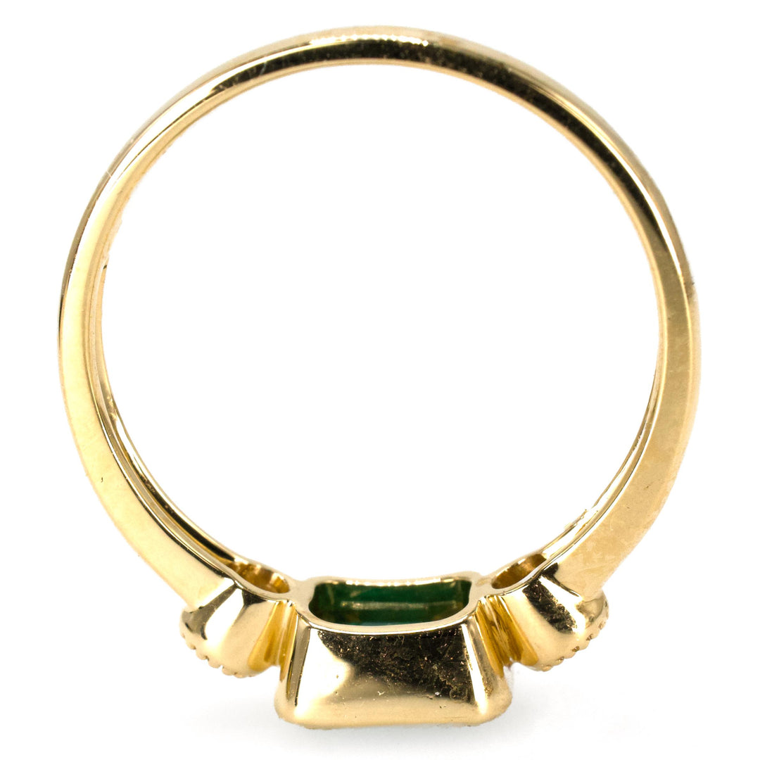 East-West Bezel Set Emerald Ring with Round Accent Diamonds in Gold