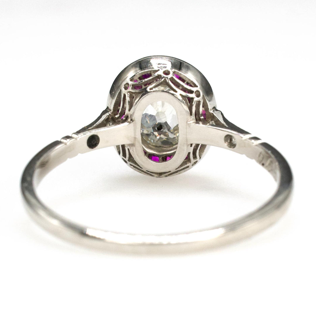 Art Deco Platinum Ring with 0.75 Carat Antique Oval Cut Diamond and Ruby Halo