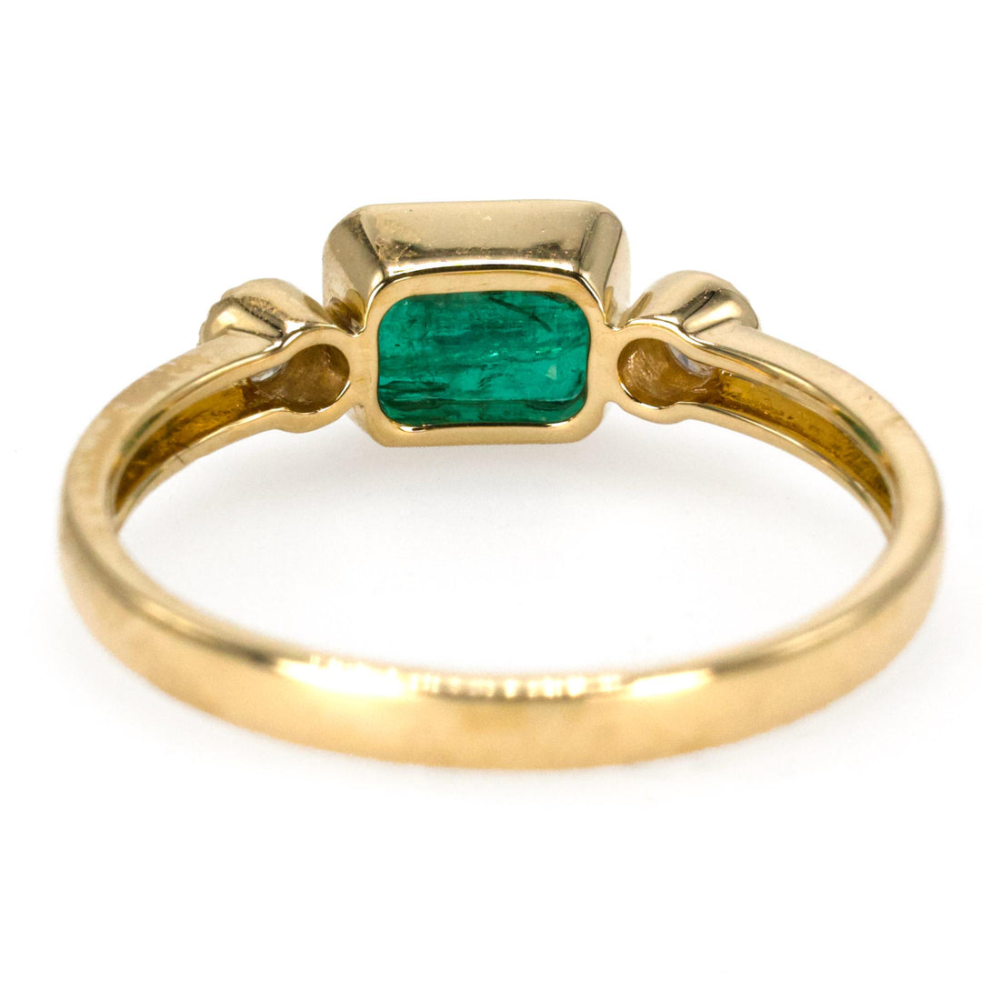 East-West Bezel Set Emerald Ring with Round Accent Diamonds in Gold