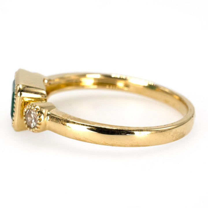 East-West Bezel Set Emerald Ring with Round Accent Diamonds in Gold