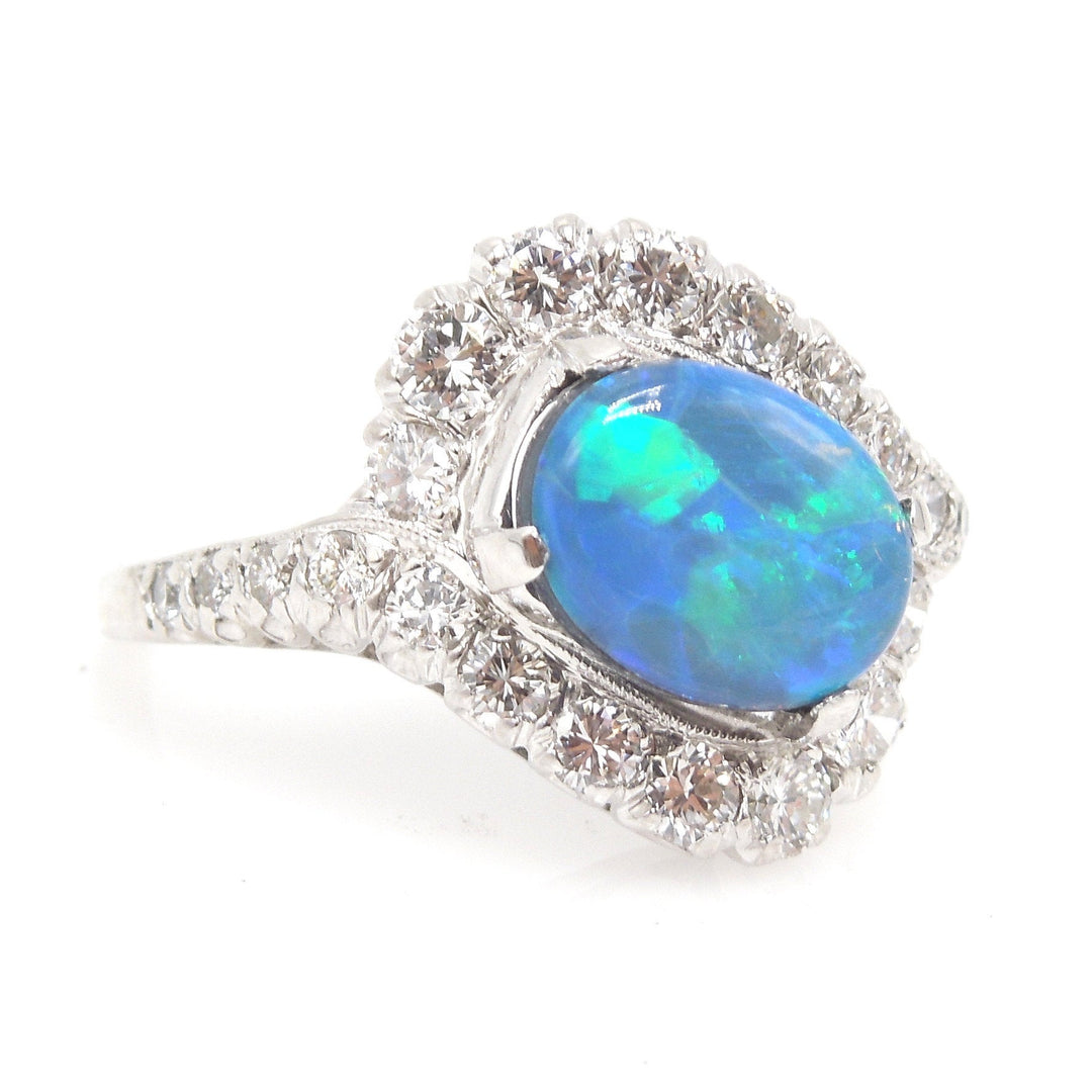 Oval Black Opal Surrounded by a Swirl of Diamonds in White Gold