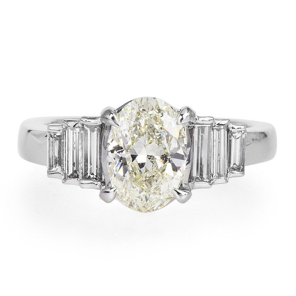 Warm Toned 1.50 carat Oval Cut Diamond in Platinum Engagement Ring with Graduated Baguettes