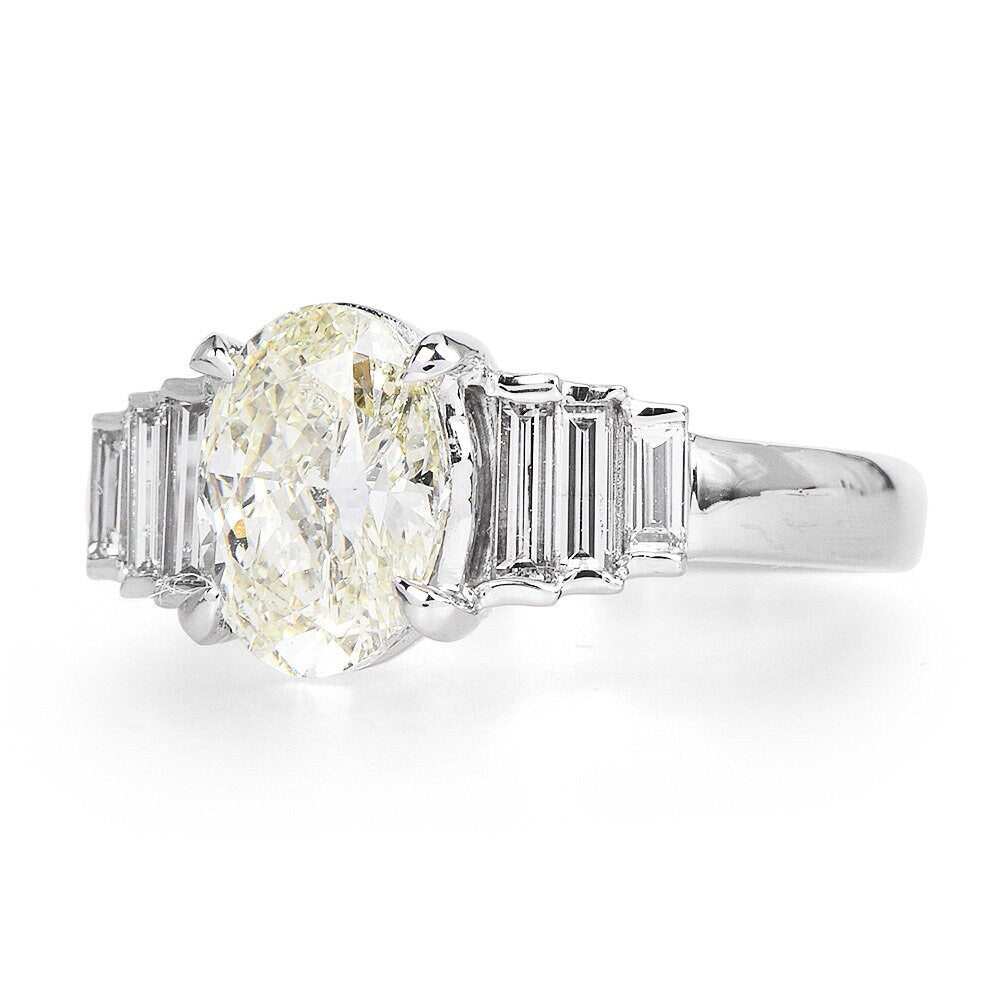 Warm Toned 1.50 carat Oval Cut Diamond in Platinum Engagement Ring with Graduated Baguettes