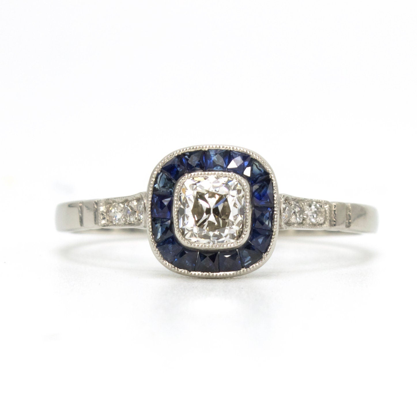 Antique Cushion Cut Diamond Target Ring with French Cut Sapphire Halo in Platinum
