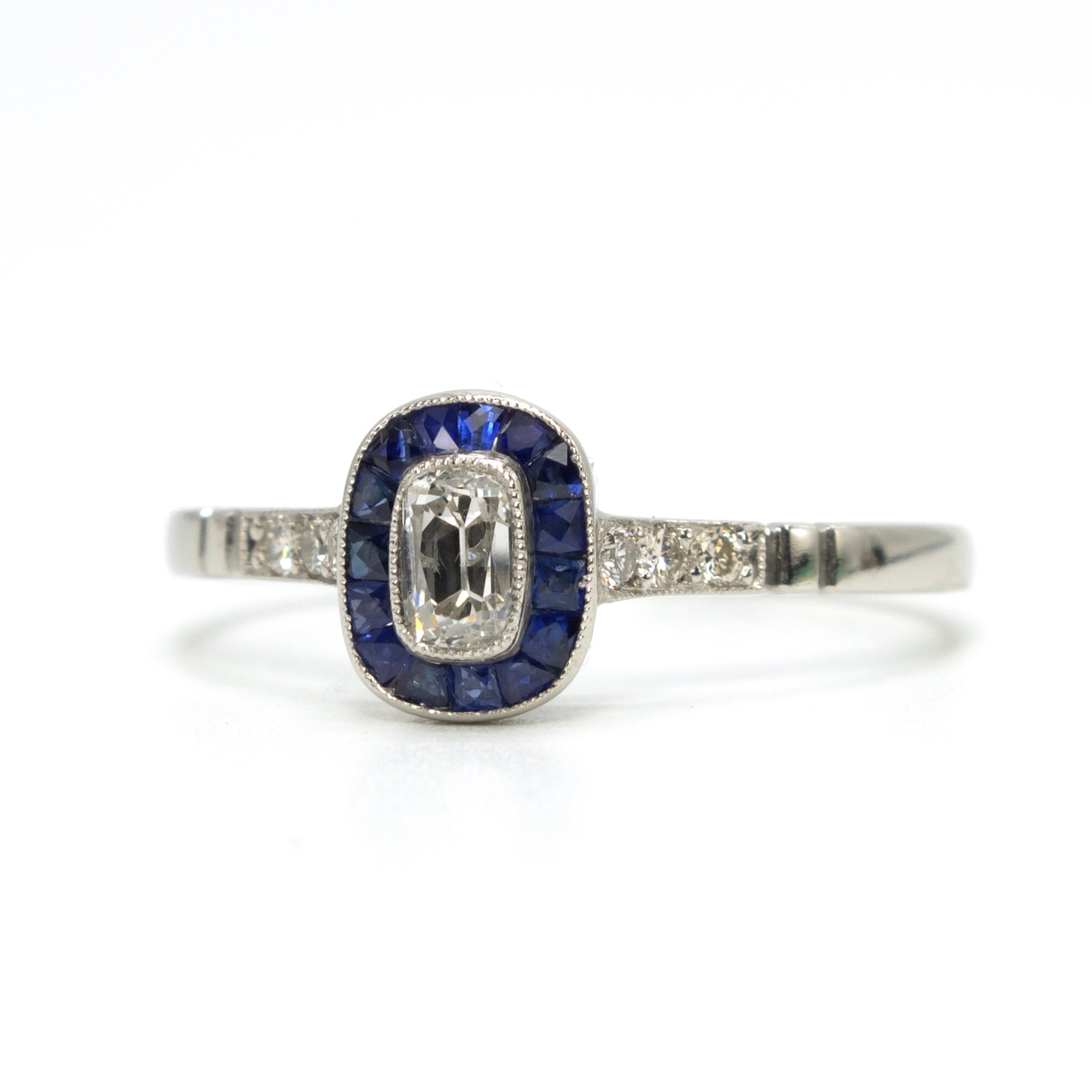 Rare and Unusual Antique Elongated Cushion Cut Diamond Target Ring with French Cut Sapphire Halo in Platinum