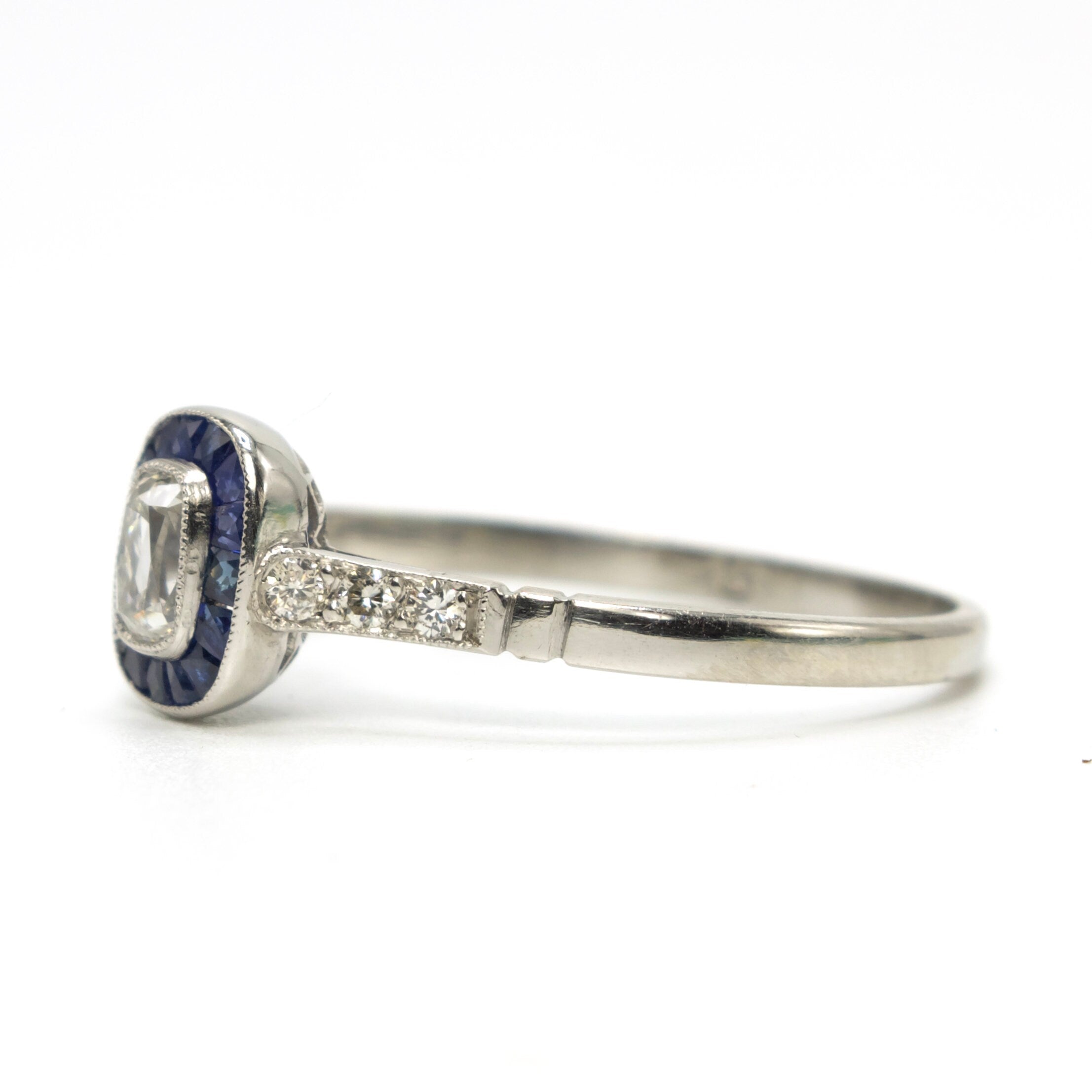 Rare and Unusual Antique Elongated Cushion Cut Diamond Target Ring with French Cut Sapphire Halo in Platinum
