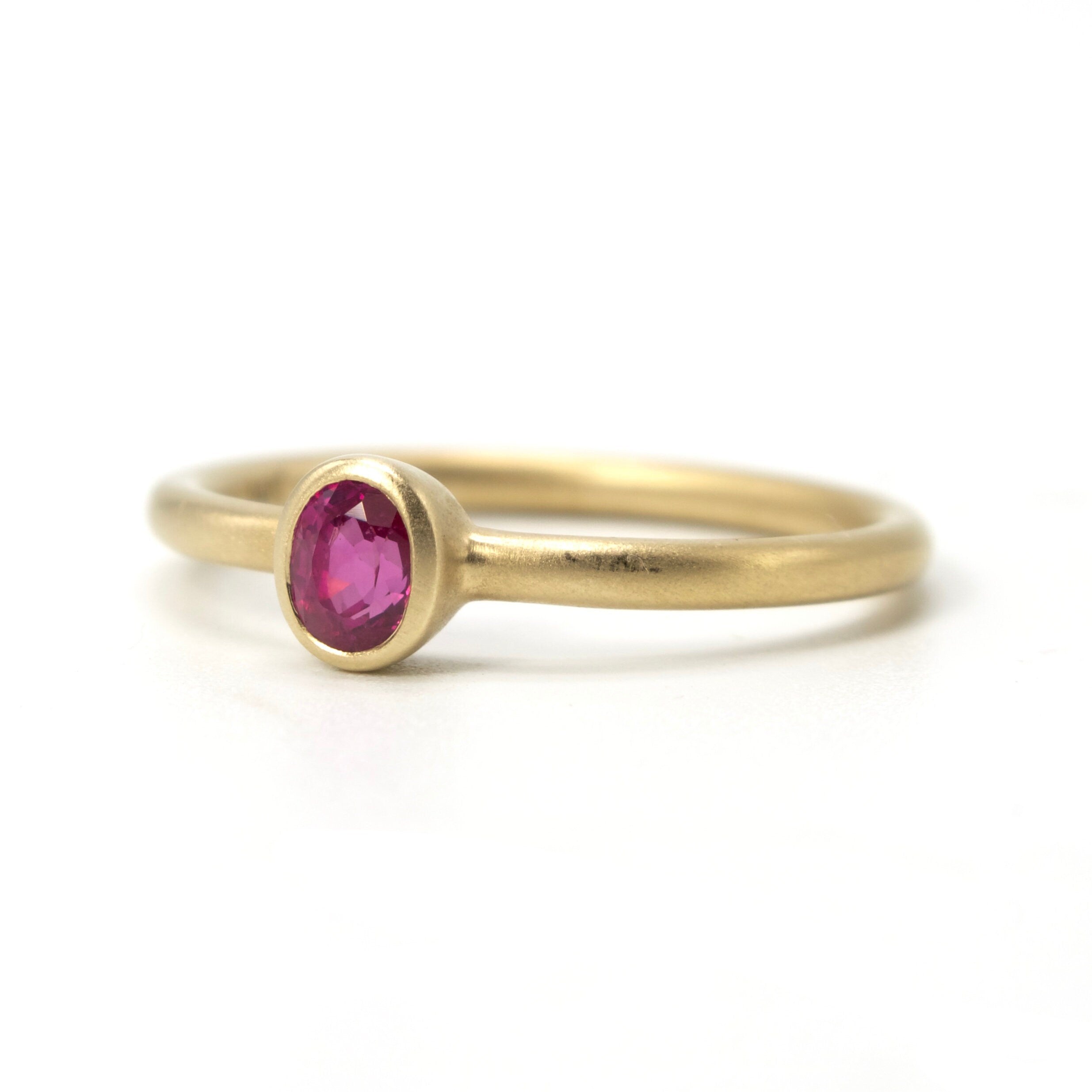 Bezel Set Oval Cut Ruby Solitaire in Brushed Gold Mounting